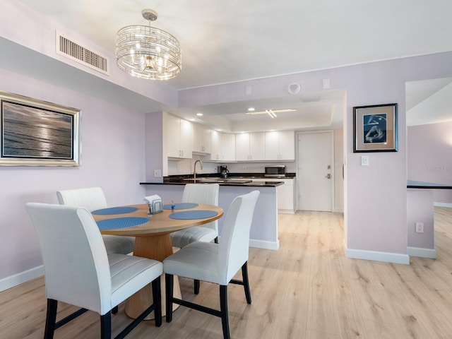 2295 Gulf Of Mexico Dr Unit 64S, Longboat Key, FL 34228 - dining space with a chandelier, light wood finished floors, and a raised ceiling