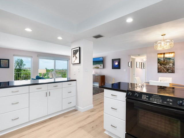 2295 Gulf Of Mexico Dr Unit 64S, Longboat Key, FL 34228 - kitchen with black / electric stove, light wood-style flooring, dark countertops, white cabinets, and recessed lighting