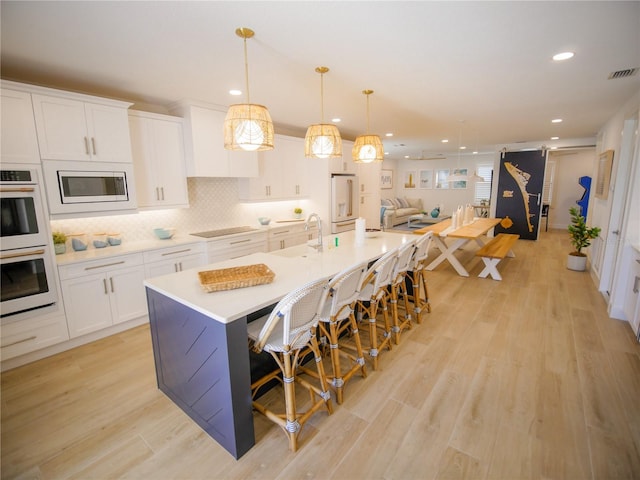 111 6th St N, Bradenton Beach, FL 34217 - kitchen with white appliances, white cabinetry, recessed lighting, open floor plan, and backsplash