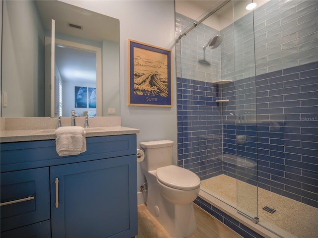 111 6th St N, Bradenton Beach, FL 34217 - bathroom featuring tiled shower, vanity, and wood finished floors