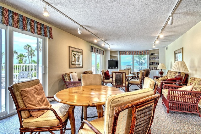 4325 Gulf Of Mexico Dr Unit 204, Longboat Key, FL 34228 - dining room with track lighting, plenty of natural light, a textured ceiling, and carpet flooring