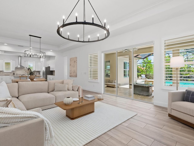 10120 Carnoustie Pl, Bradenton, FL 34211 - living room with a chandelier, ornamental molding, light wood-style flooring, a raised ceiling, and recessed lighting