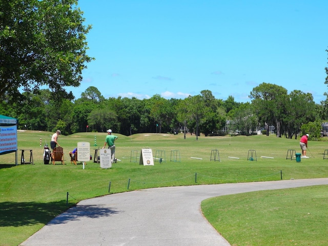 10120 Carnoustie Pl, Bradenton, FL 34211 - surrounding community with a lawn and view of wooded area