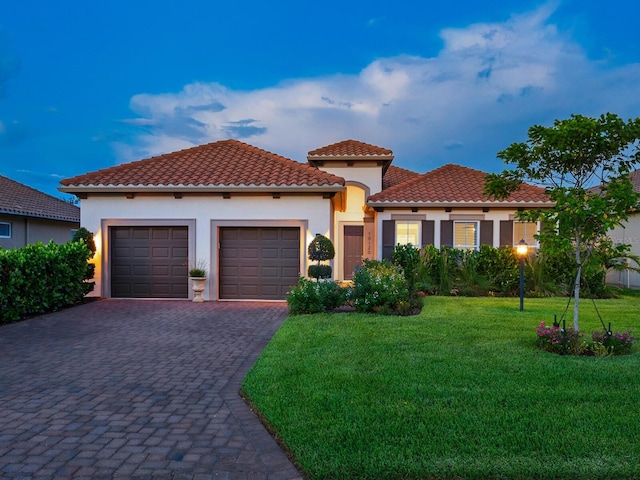 10120 Carnoustie Pl, Bradenton, FL 34211 - mediterranean / spanish-style home with decorative driveway, an attached garage, stucco siding, a yard, and a tiled roof