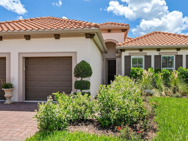 10120 Carnoustie Pl, Bradenton, FL 34211 - mediterranean / spanish-style house featuring a tile roof, stucco siding, an attached garage, and driveway