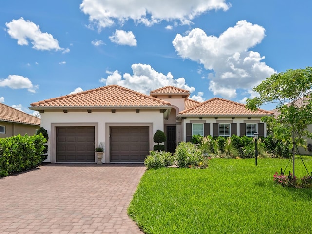 10120 Carnoustie Pl, Bradenton, FL 34211 - mediterranean / spanish house featuring an attached garage, driveway, stucco siding, and a front yard