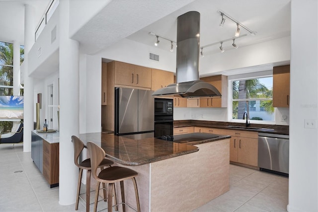 1168 Westway Dr, Sarasota, FL 34236 - kitchen with black appliances, island exhaust hood, light tile patterned floors, and a peninsula