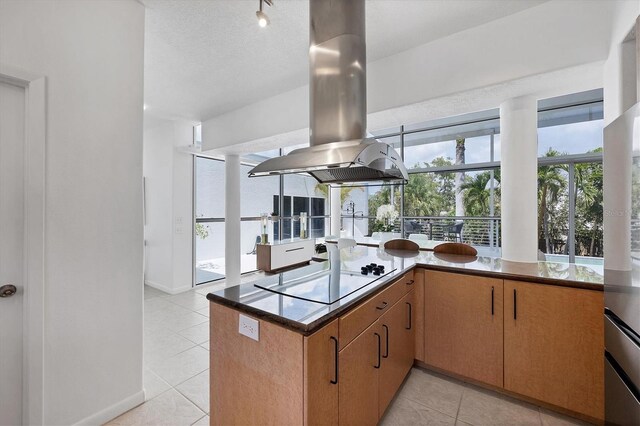 1168 Westway Dr, Sarasota, FL 34236 - kitchen with island range hood, black electric cooktop, light tile patterned floors, and a peninsula