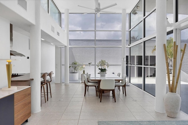 1168 Westway Dr, Sarasota, FL 34236 - dining space with ceiling fan, a high ceiling, light tile patterned floors, and floor to ceiling windows