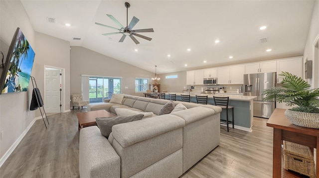 6435 165th Dr E, Parrish, FL 34219 - living area featuring light wood finished floors, ceiling fan, high vaulted ceiling, recessed lighting, and a chandelier