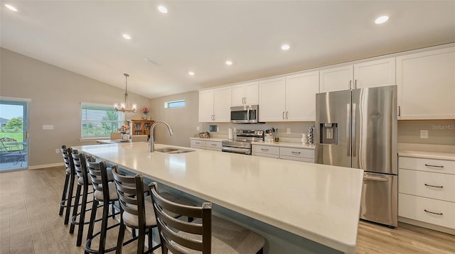 6435 165th Dr E, Parrish, FL 34219 - kitchen with stainless steel appliances, vaulted ceiling, a large island with sink, white cabinets, and recessed lighting