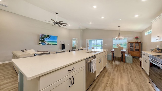 6435 165th Dr E, Parrish, FL 34219 - kitchen featuring stainless steel appliances, light wood-type flooring, white cabinets, lofted ceiling, and light countertops