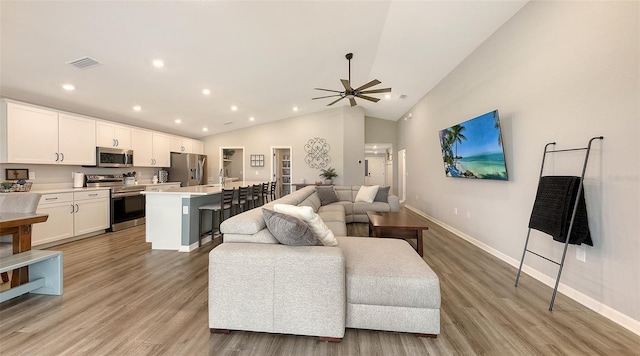 6435 165th Dr E, Parrish, FL 34219 - living area featuring light wood-style flooring, vaulted ceiling, a ceiling fan, and recessed lighting