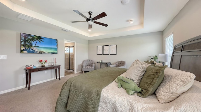 6435 165th Dr E, Parrish, FL 34219 - bedroom with a tray ceiling, light carpet, ceiling fan, and connected bathroom