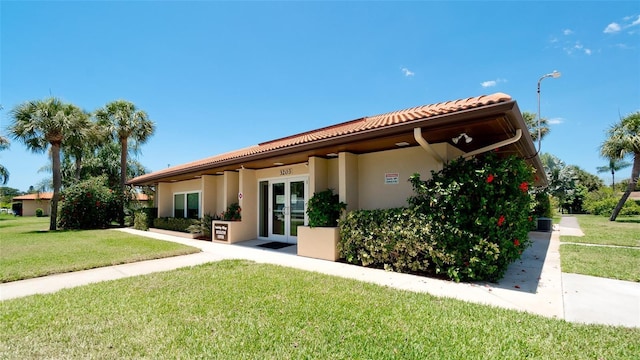 3305 Notre Dame Pl Unit 3305, Bradenton, FL 34207 - back of property with french doors, a lawn, stucco siding, and a tile roof