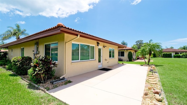 3305 Notre Dame Pl Unit 3305, Bradenton, FL 34207 - back of house with stucco siding, a patio, a yard, and a tiled roof