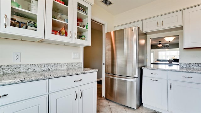 3305 Notre Dame Pl Unit 3305, Bradenton, FL 34207 - kitchen with freestanding refrigerator, white cabinets, glass insert cabinets, and light tile patterned floors