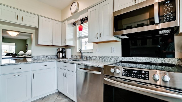 3305 Notre Dame Pl Unit 3305, Bradenton, FL 34207 - kitchen featuring stainless steel appliances, white cabinets, light stone countertops, and light tile patterned floors