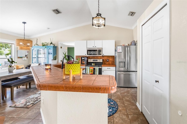 6178 Coliseum Blvd, Port Charlotte, FL 33981 - kitchen featuring appliances with stainless steel finishes, a chandelier, white cabinetry, tile countertops, and tasteful backsplash