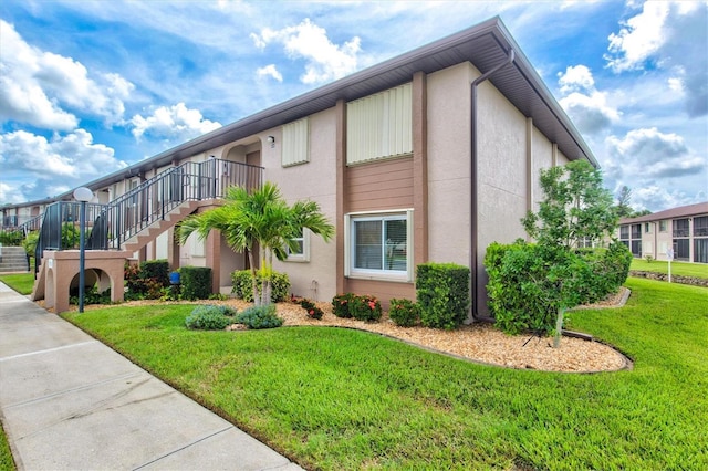 25100 Sandhill Blvd Unit 104G, Punta Gorda, FL 33983 - view of home's exterior featuring stucco siding, a lawn, and stairway