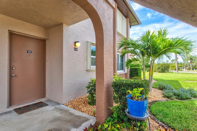 25100 Sandhill Blvd Unit 104G, Punta Gorda, FL 33983 - doorway to property featuring stucco siding and a lawn