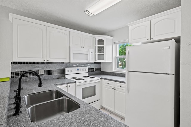 25100 Sandhill Blvd Unit 104G, Punta Gorda, FL 33983 - kitchen with white appliances, white cabinets, tasteful backsplash, and glass insert cabinets