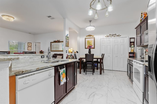 25324 Alicante Dr, Punta Gorda, FL 33955 - kitchen featuring white appliances, light marble finish floors, decorative light fixtures, light stone counters, and dark brown cabinetry