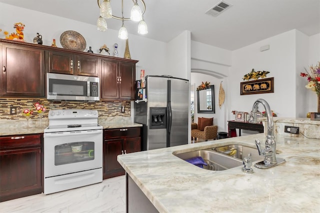 25324 Alicante Dr, Punta Gorda, FL 33955 - kitchen featuring stainless steel appliances, light marble finish flooring, tasteful backsplash, and dark brown cabinets
