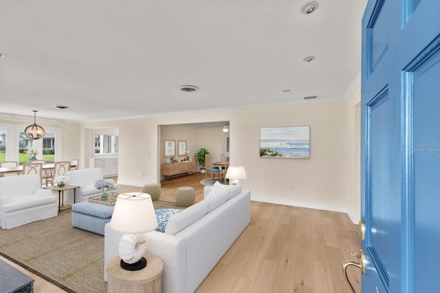 2401 Riverview Blvd, Bradenton, FL 34205 - living room featuring crown molding, light wood finished floors, and a chandelier