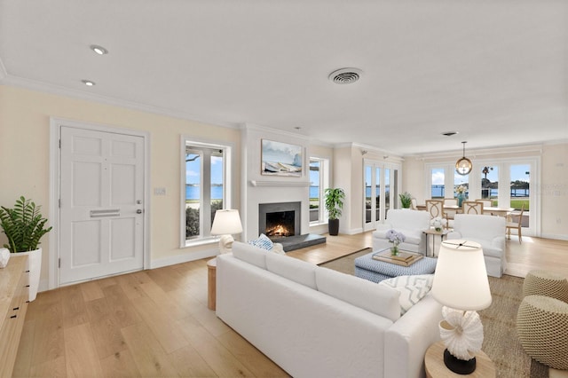 2401 Riverview Blvd, Bradenton, FL 34205 - living area featuring light wood finished floors, a lit fireplace, ornamental molding, and recessed lighting