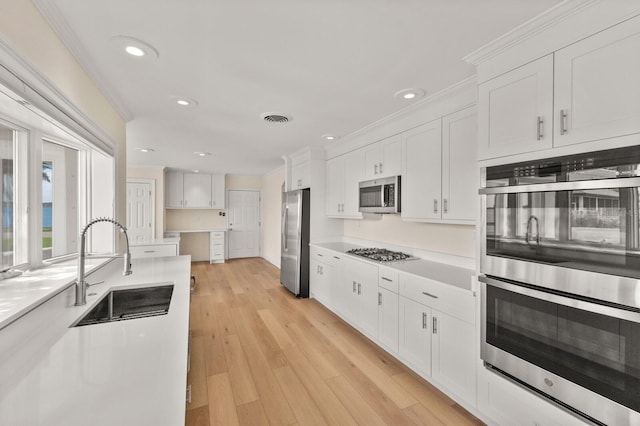 2401 Riverview Blvd, Bradenton, FL 34205 - kitchen with appliances with stainless steel finishes, white cabinets, recessed lighting, light countertops, and light wood-type flooring