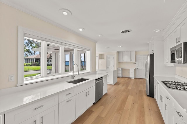 2401 Riverview Blvd, Bradenton, FL 34205 - kitchen featuring stainless steel appliances, white cabinets, ornamental molding, recessed lighting, and light countertops