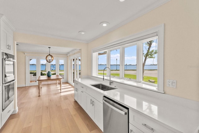 2401 Riverview Blvd, Bradenton, FL 34205 - kitchen with appliances with stainless steel finishes, ornamental molding, light countertops, plenty of natural light, and a water view