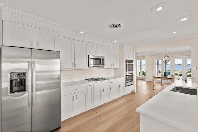 2401 Riverview Blvd, Bradenton, FL 34205 - kitchen with appliances with stainless steel finishes, white cabinetry, recessed lighting, light countertops, and decorative light fixtures