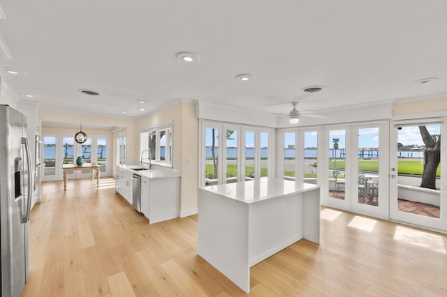 2401 Riverview Blvd, Bradenton, FL 34205 - kitchen with appliances with stainless steel finishes, french doors, light countertops, ornamental molding, and light wood finished floors