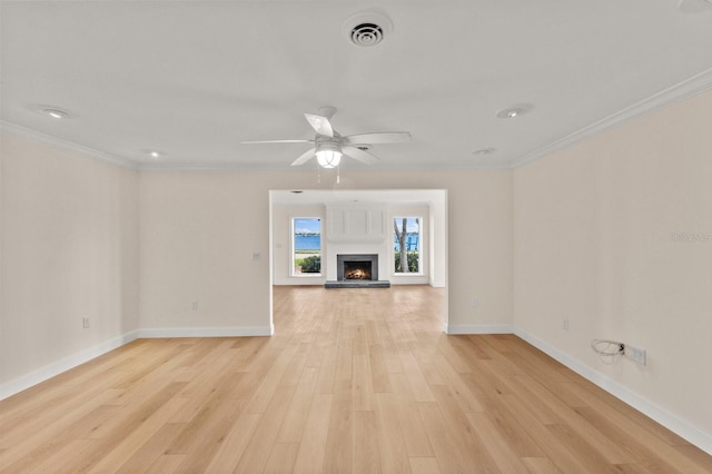 2401 Riverview Blvd, Bradenton, FL 34205 - unfurnished living room featuring light wood-type flooring, crown molding, ceiling fan, and a lit fireplace