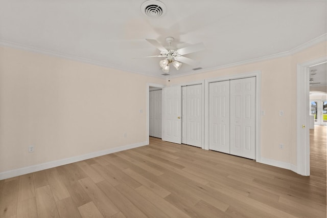 2401 Riverview Blvd, Bradenton, FL 34205 - unfurnished bedroom with multiple closets, light wood-style floors, ornamental molding, and ceiling fan