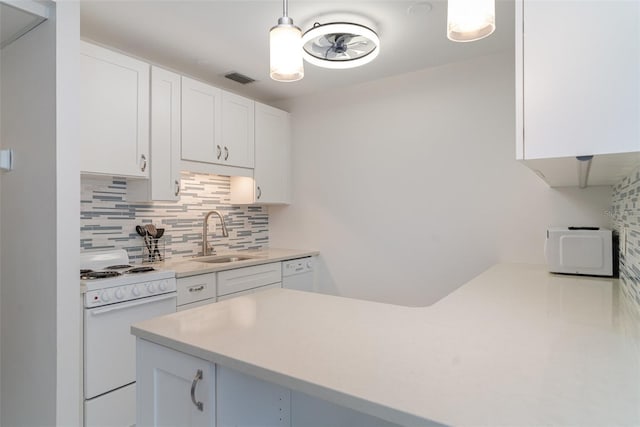 1400 1st Ave W Unit 103, Bradenton, FL 34205 - kitchen featuring white appliances, decorative backsplash, white cabinets, light countertops, and pendant lighting