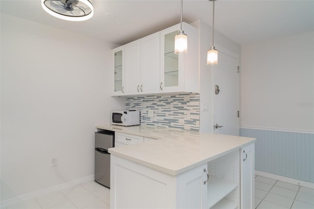 1400 1st Ave W Unit 103, Bradenton, FL 34205 - kitchen with open shelves, tasteful backsplash, white cabinets, light countertops, and refrigerator