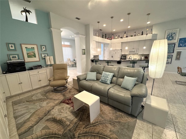 8616 15th Ave NW, Bradenton, FL 34209 - living area with ornate columns, arched walkways, light tile patterned floors, a high ceiling, and recessed lighting