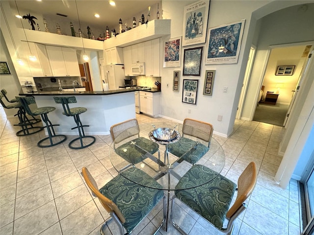 8616 15th Ave NW, Bradenton, FL 34209 - dining space featuring arched walkways, light tile patterned flooring, and a high ceiling