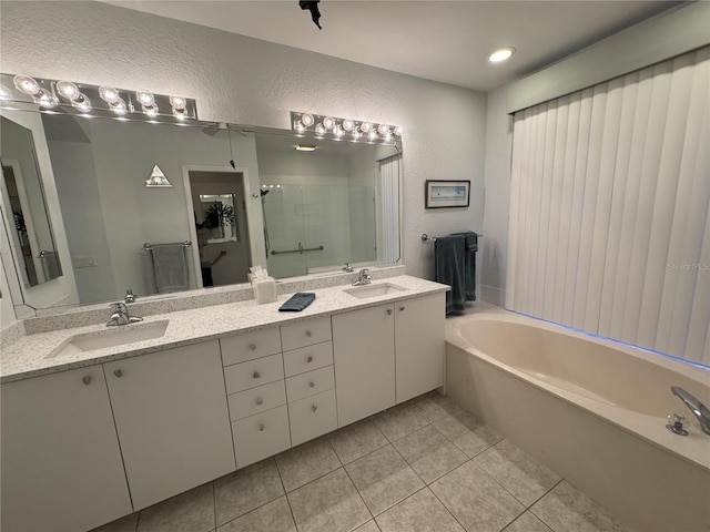 8616 15th Ave NW, Bradenton, FL 34209 - bathroom with double vanity, a garden tub, a shower stall, tile patterned flooring, and a textured wall