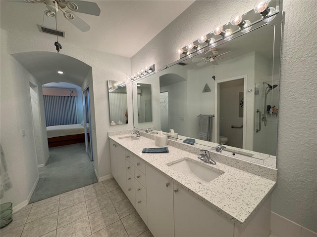 8616 15th Ave NW, Bradenton, FL 34209 - ensuite bathroom featuring a ceiling fan, a textured wall, double vanity, tile patterned flooring, and a shower