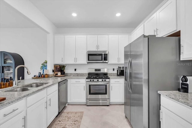 15131 Sunny Day Dr, Bradenton, FL 34211 - kitchen with appliances with stainless steel finishes, white cabinetry, light stone counters, and recessed lighting