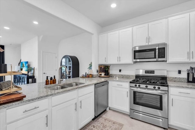 15131 Sunny Day Dr, Bradenton, FL 34211 - kitchen with stainless steel appliances, white cabinets, recessed lighting, light stone counters, and a peninsula
