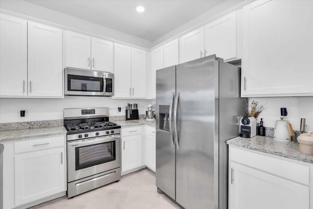 15131 Sunny Day Dr, Bradenton, FL 34211 - kitchen featuring appliances with stainless steel finishes, white cabinets, recessed lighting, and light stone countertops