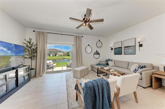 5711 Archipelago St, Nokomis, FL 34275 - living area featuring light tile patterned floors, a ceiling fan, and a water view