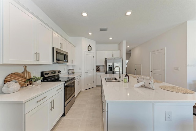 5711 Archipelago St, Nokomis, FL 34275 - kitchen featuring stainless steel appliances, light tile patterned floors, white cabinetry, an island with sink, and light countertops