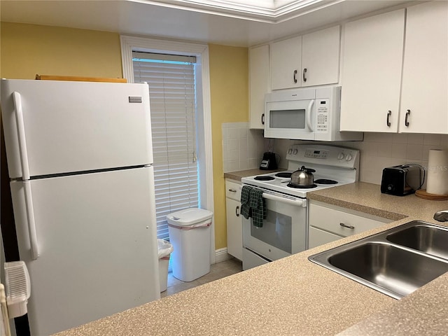 5310 Gulf Of Mexico Dr Unit 18, Longboat Key, FL 34228 - kitchen with white appliances, white cabinetry, tasteful backsplash, and light countertops