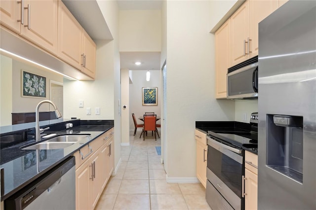 1064 N Tamiami Trl Unit 1125, Sarasota, FL 34236 - kitchen with stainless steel appliances, light tile patterned floors, dark stone counters, and recessed lighting